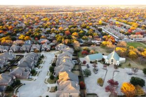 Roanoke, TX - Aerial View of Homes in Roanoke Texas Surrounded by Colorful Fall Trees at Sunset